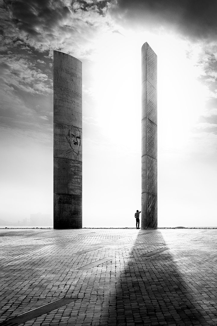 Figuras humanas entre dos grandes muros verticales de piedra.